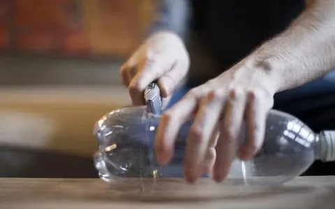 A person is cutting a plastic bottle