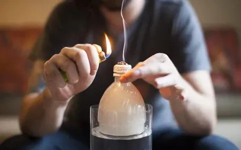 A man is lighting the cannabis of your gravity bong